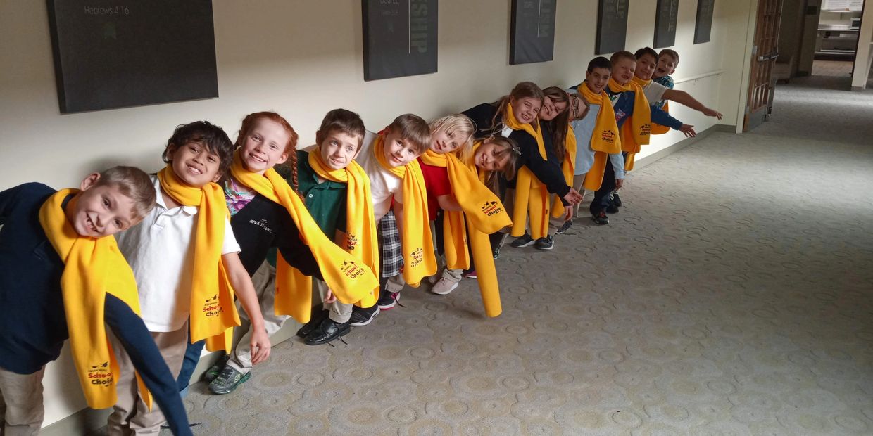 a Group of smiling students in the school hallway with School Choice scarves on