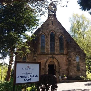 Stone church building with a sign welcoming visitors to St Machar's Ranfurly Church.