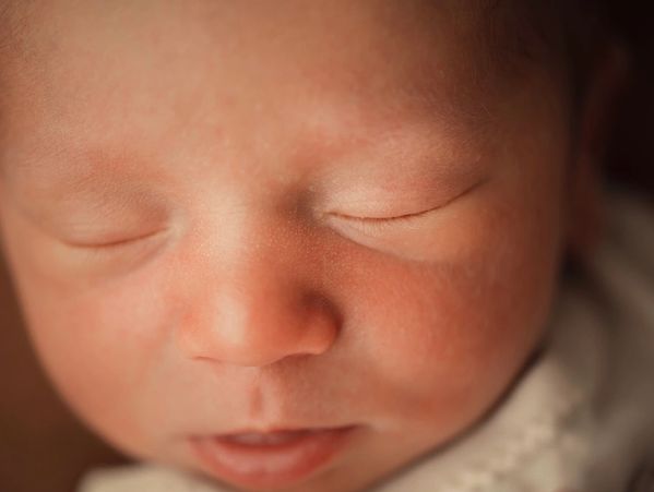 Close-up of a newborn baby peacefully sleeping with eyes closed.