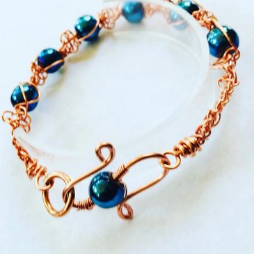20 gauge copper wire macrame bracelet with blue glass beads.