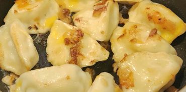 Golden brown pan-fried dumplings with crispy bits on top.