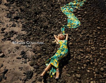 Model Maggie Coulombe poses on rocky ground in a vibrant tropical dress in Maui.