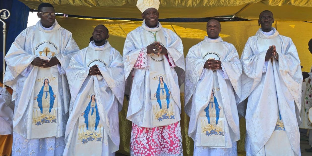Cinco sacerdotes en vestimentas religiosas blancas con un fondo amarillo.