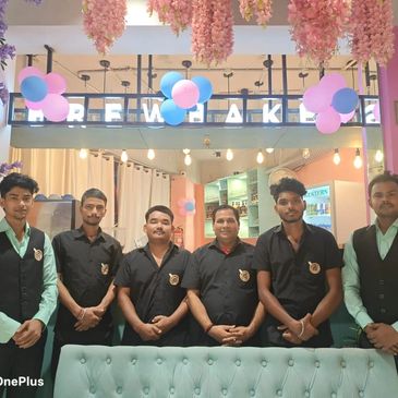 Group of six men in uniform posing in a decorated indoor setting.