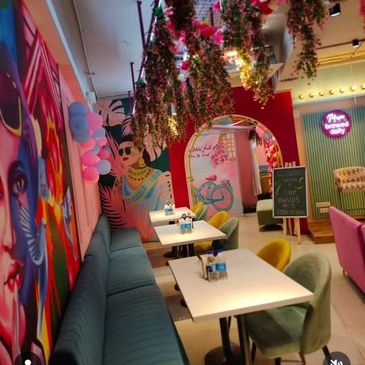 Colorful cafe interior with floral decorations and vibrant wall art.