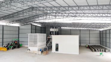 Large industrial warehouse with machinery and workers.
