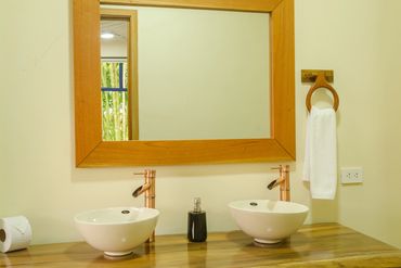 Baño, lavamanos y espejo en suite para pareja