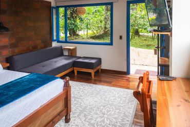 Sala de estar en habitacion para pareja con vista al jardin