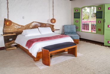 Cama en suite con vistas de paisaje en hotel campestre en quindio