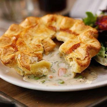 Golden-brown chicken pot pie with creamy filling and vegetables.