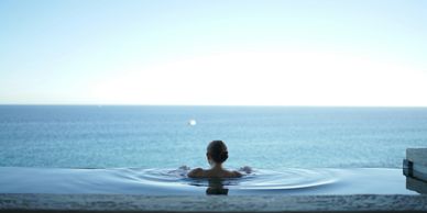 woman in infinity pool looking out to sea