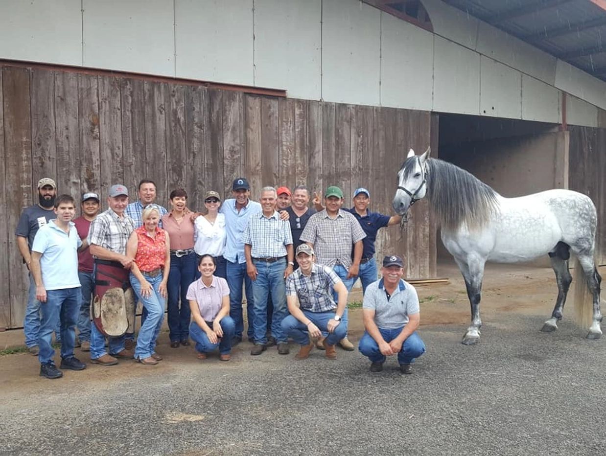 Group photo of Sabaneros Cowboy Culture in Costa Rica. People with one beautiful grey horse.
