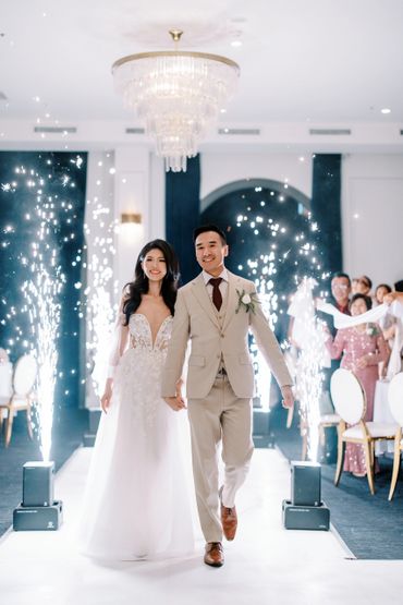 A joyful couple walks down the aisle amid sparkling fireworks at their wedding.