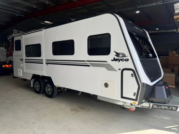 White Jayco Silverline caravan parked inside a warehouse.