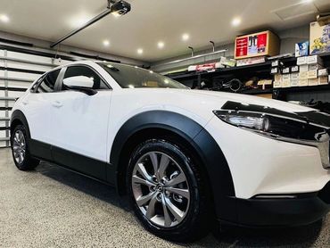 White crossover SUV parked inside a clean, well-lit garage.