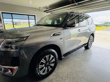 Sleek silver Nissan Patrol V8 parked inside a modern garage.
