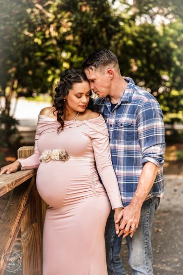 Maternity portrait of couple by wooden fence in Charleston