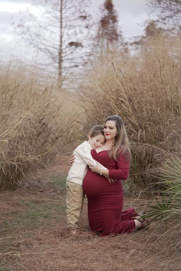 Elizabeth Grace Smith kneeling in a gold field in Summerville, SC with son