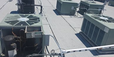 Multiple rooftop HVAC units and air conditioning systems installed on a flat roof.