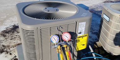 HVAC unit with attached pressure gauges on a rooftop.