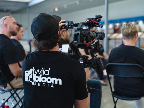 Videographer filming at an indoor event with a professional camera.