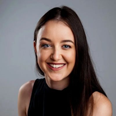 Young woman with long dark hair smiling.
