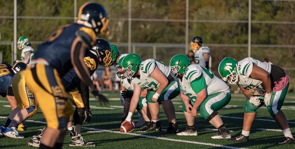 Two football teams lined up against each other on the field before a play.