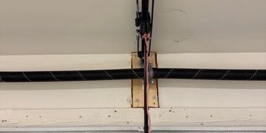Garage door mechanism with a red emergency release cord.