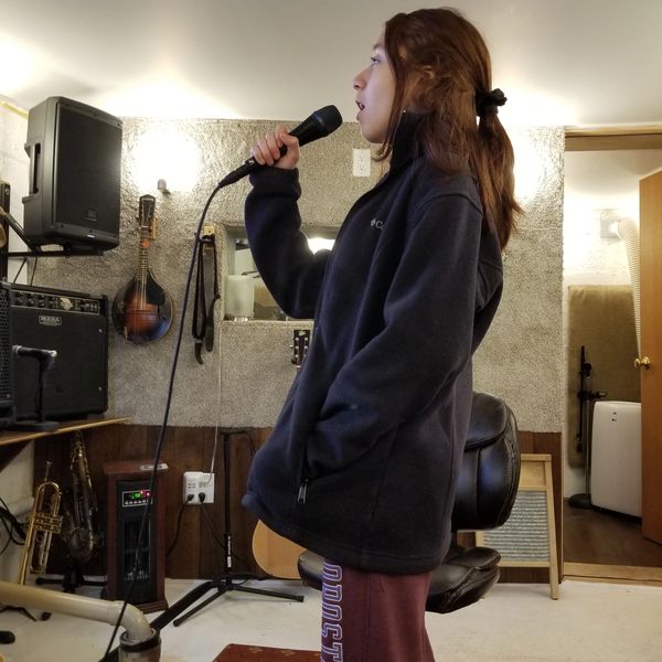 Student singing loud in her vocal lesson.