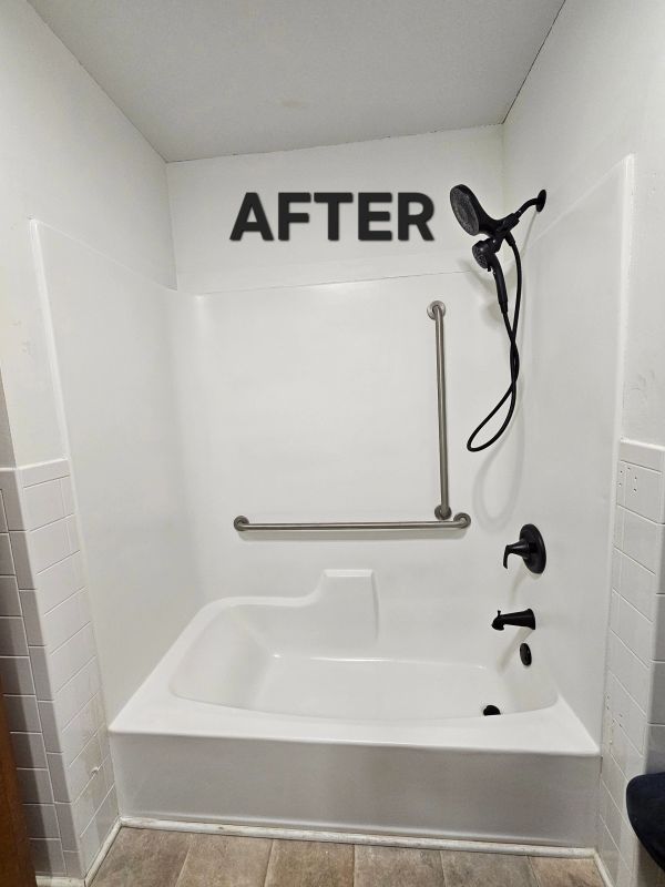 A renovated white bathtub with black fixtures and safety grab bars.