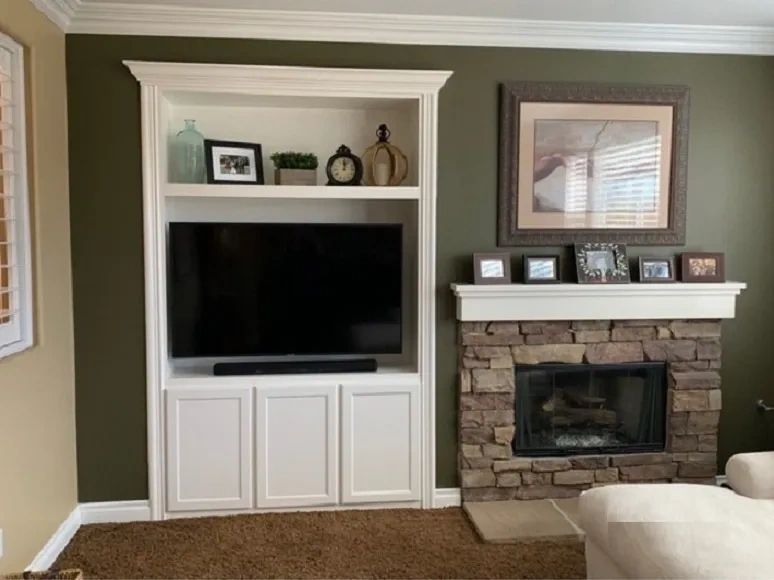 An entertainment center built into the wall with shaker style cabinet door panels.