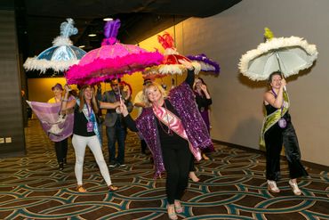 men and women walking with umbrellas