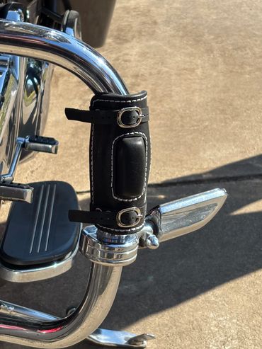 Chrome-detailed motorcycle engine with black leather cup holder accessory.