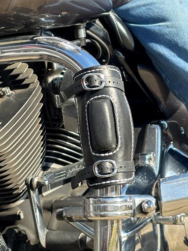 Motorcycle engine's chrome details paired with a stylish black leather cup holder.