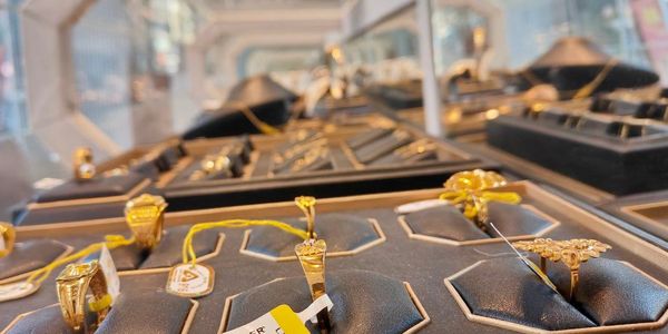 Close-up of gold rings displayed in a jewelry store with price tags.