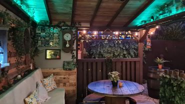 Cozy outdoor seating area with wooden decor, soft cushions, and ambient lighting.