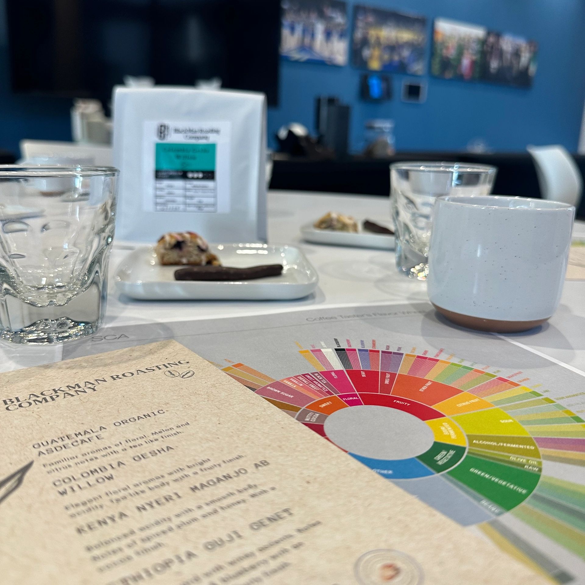 Coffee tasting setup with flavor wheel and samples at Blackman Roasting Company.