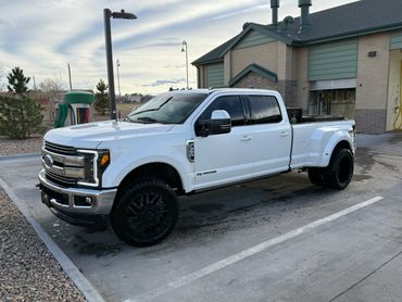 White Ford F-350 pickup truck parked near a building.