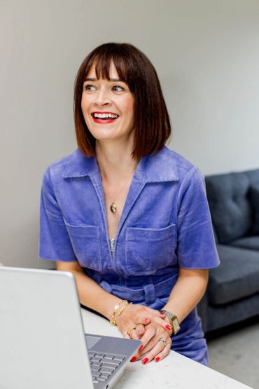 Woman smiling on laptop.