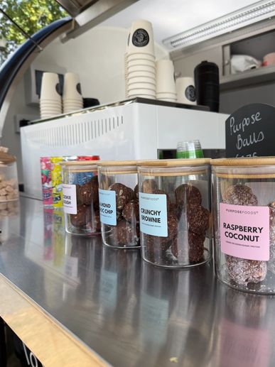 Assorted energy balls in clear jars with wooden lids.