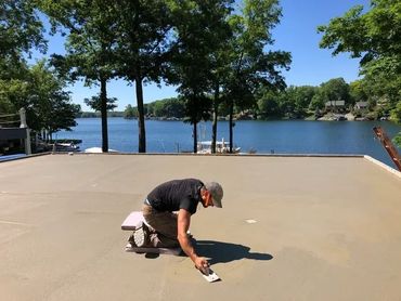 A concrete contractor hand troweling a slick finish or trowel finish concrete garage slab