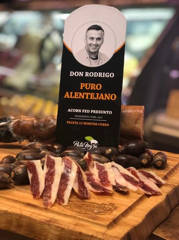 Slices of cured pork with a label reading Don Rodrigo Puro Alentejano on a wooden board.