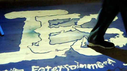 Logo projected on the floor ripples as people move thru it