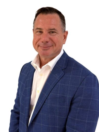 Man in blue blazer smiling at camera.