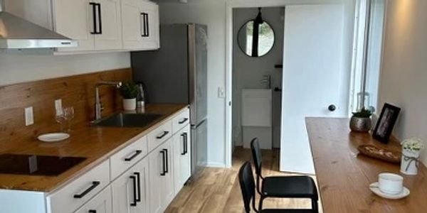 Compact modern kitchen with wooden countertops and bar seating.
