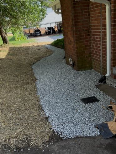 French drain / walking path integration to remove standing water from the back of their house