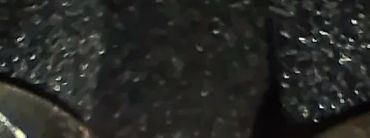 Two engraved metal rings displayed on black holders.