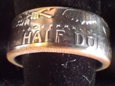 A ring made from a coin with the inscription 'HALF DOL'.