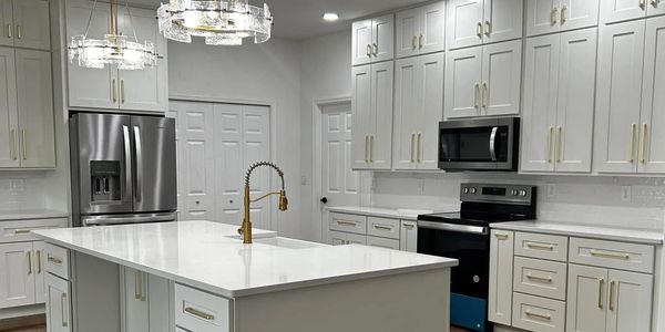 Modern kitchen with white shaker cabinets with gold fixtures