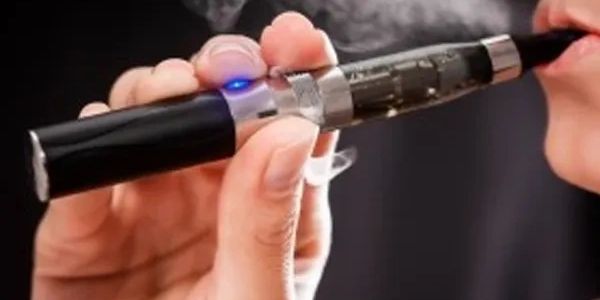 Person holding and using an electronic cigarette.